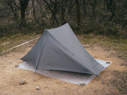 Gray tent set up on a campsite